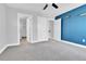 Spacious bedroom with neutral carpet, two doors, ensuite bathroom, and a blue accent wall at 1270 Winona Ct, Denver, CO 80204