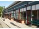 Charming street view with a row of commercial buildings, flower planters, and a bench at 1270 Winona Ct, Denver, CO 80204