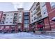 Condominium building with multiple floors, street-level retail, and balconies, captured on a snowy day at 10111 Inverness Main St # 425, Englewood, CO 80112