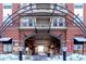 Covered walkway between buildings, featuring brick facade and arched metal structure in winter season at 10111 Inverness Main St # 425, Englewood, CO 80112