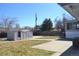 Large backyard with storage shed, concrete patio, and partial view of home's sunroom at 4642 Everett Ct, Wheat Ridge, CO 80033