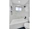 Clean bathroom featuring tiled walls, sleek fixtures, and a window above the tub at 4642 Everett Ct, Wheat Ridge, CO 80033