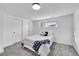 Bright bedroom with soft gray carpet, a queen-size bed and sliding door closet at 4642 Everett Ct, Wheat Ridge, CO 80033