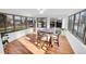 Sunlit dining area featuring hardwood floors, large windows, and a modern table set for four at 4642 Everett Ct, Wheat Ridge, CO 80033