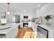 Modern kitchen with stainless steel appliances, quartz countertops, white cabinets, and hardwood flooring at 4642 Everett Ct, Wheat Ridge, CO 80033
