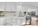 Bright kitchen showcasing white cabinets, stainless steel appliances, quartz countertops, and hardwood flooring at 4642 Everett Ct, Wheat Ridge, CO 80033