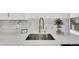 A modern kitchen features a stainless steel sink with a brass faucet and marble backsplash at 4642 Everett Ct, Wheat Ridge, CO 80033