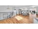 Open-concept living area and kitchen featuring hardwood floors and staircase with metal railing at 4642 Everett Ct, Wheat Ridge, CO 80033