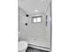 Modern shower features white tiled walls and dark accents, including the fixtures at 4642 Everett Ct, Wheat Ridge, CO 80033