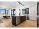 Open kitchen features large island with sink, dining space and hardwood floors at 1601 Park Ave # 216, Denver, CO 80218