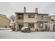 Back exterior view of a two-story townhouse with a balcony and snow-covered yard at 11919 E Yale Ave, Aurora, CO 80014