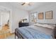 Cozy bedroom featuring a ceiling fan, wood floors, and natural light from the window at 2681 Leyden St, Denver, CO 80207