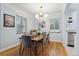 Charming dining room with a wooden table, modern chandelier, and bright windows at 2681 Leyden St, Denver, CO 80207