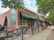 Exterior view of a brick building with multiple storefronts and outdoor seating at 2681 Leyden St, Denver, CO 80207