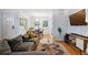 Open-concept living room with hardwood floors, comfortable seating, and access to the dining area at 2681 Leyden St, Denver, CO 80207