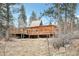 Wooden cabin with multiple decks, surrounded by lush forest and a serene outdoor landscape at 30930 Bear Cub Trl, Conifer, CO 80433