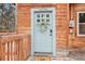 Close up of the home's light blue front door with wreath and custom door mat at 30930 Bear Cub Trl, Conifer, CO 80433