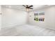Spacious bedroom featuring neutral carpet, white walls, a ceiling fan, and a large window at 11294 Bella Vita Dr, Broomfield, CO 80020