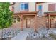 Charming townhome with a stone facade, covered entrance, and decorative rock landscaping at 11294 Bella Vita Dr, Broomfield, CO 80020