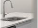 Close-up of a double stainless steel kitchen sink with a modern faucet and white countertops at 11294 Bella Vita Dr, Broomfield, CO 80020
