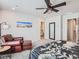 Comfortable main bedroom showcasing a ceiling fan, accent chair, and ensuite bathroom access at 11294 Bella Vita Dr, Broomfield, CO 80020