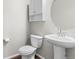 Well-lit powder room featuring a pedestal sink, toilet, and storage cabinet at 11294 Bella Vita Dr, Broomfield, CO 80020