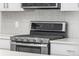 Stainless steel stove with overhead microwave and decorative tiled backsplash at 11294 Bella Vita Dr, Broomfield, CO 80020