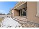 Back patio with stone detail, outdoor living space, and sliding glass doors at 160 Pipit Lake Way, Erie, CO 80516