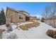 Spacious backyard with partial snow cover and a well-maintained lawn and patio area at 160 Pipit Lake Way, Erie, CO 80516