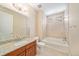 Bright bathroom featuring bathtub and shower with tile surround and vanity with granite countertop at 160 Pipit Lake Way, Erie, CO 80516