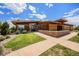 Modern clubhouse exterior featuring a wooden design, landscaped surroundings, and a welcoming entrance path at 160 Pipit Lake Way, Erie, CO 80516