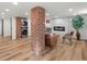 Renovated basement with exposed brick, laundry, modern fireplace, hardwood floors, and recessed lights at 1640 E Virginia Ave, Denver, CO 80209