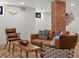 Inviting basement living area features brick pillar, modern furniture, hardwood floors, and recessed lights at 1640 E Virginia Ave, Denver, CO 80209