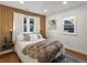 Inviting bedroom with a textured wood accent wall, soft lighting, and a comfortable bed with stylish throw pillows at 1640 E Virginia Ave, Denver, CO 80209