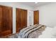 Bedroom featuring a white and black patterned rug, warm wood doors, and a faux fur throw blanket at 1640 E Virginia Ave, Denver, CO 80209