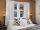 Comfortable bedroom featuring decorative pillows, stylish lamps, and wood-slat feature wall at 1640 E Virginia Ave, Denver, CO 80209