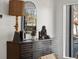 Elegant dresser featuring unique decor with natural light from windows with an arched mirror on top at 1640 E Virginia Ave, Denver, CO 80209