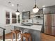 Modern kitchen with gray cabinets, stainless steel appliances, and an island with a white countertop and pendant lighting at 1640 E Virginia Ave, Denver, CO 80209