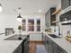 Open kitchen with gray cabinets, stainless steel appliances, an island with a cooktop, and a view to the dining area at 1640 E Virginia Ave, Denver, CO 80209