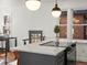 Bright kitchen featuring an island with a cooktop, white countertops, pendant lights, and large windows with a view at 1640 E Virginia Ave, Denver, CO 80209