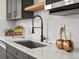 Close-up of a modern kitchen sink, white countertops, gray cabinets, and decorative golden apple accents at 1640 E Virginia Ave, Denver, CO 80209