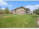 Well-maintained backyard with gentle slope, complemented by a stone facade and covered patio at 19379 W 57Th Pl, Golden, CO 80403