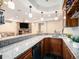 Elegant basement bar with granite counters and wood cabinets, adjacent to a cozy entertaining area at 19379 W 57Th Pl, Golden, CO 80403