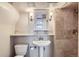 Cozy bathroom featuring a pedestal sink, classic fixtures, and tiled shower at 1120 Holly St, Denver, CO 80220