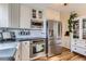 Well-equipped kitchen featuring white cabinets, stainless steel appliances, and modern fixtures at 1120 Holly St, Denver, CO 80220