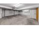 Spacious two car garage with concrete floors, electric door, and shelving at 1050 S Monaco Pkwy # 68, Denver, CO 80224