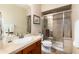 Bright bathroom features a shower with glass door, neutral color palette, and a sink with ample counter space at 2042 S Clayton St, Denver, CO 80210