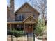 Charming home featuring a stone chimney, well-manicured landscaping, and inviting front porch at 2042 S Clayton St, Denver, CO 80210