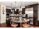 Gourmet kitchen with dark cabinetry, stainless steel appliances, granite counters and a center island with bar seating at 2042 S Clayton St, Denver, CO 80210