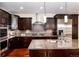 Modern kitchen boasts dark cabinetry, stainless steel appliances, granite counters, and a stylish range hood at 2042 S Clayton St, Denver, CO 80210